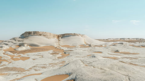 Desert landscape with white rock formations under a clear blue sky
